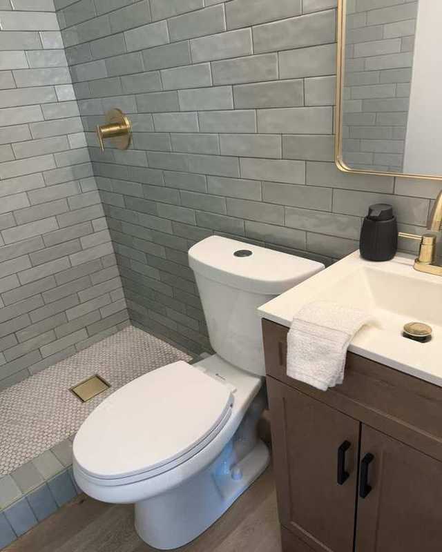 Baño remodelado con inodoro y regadera